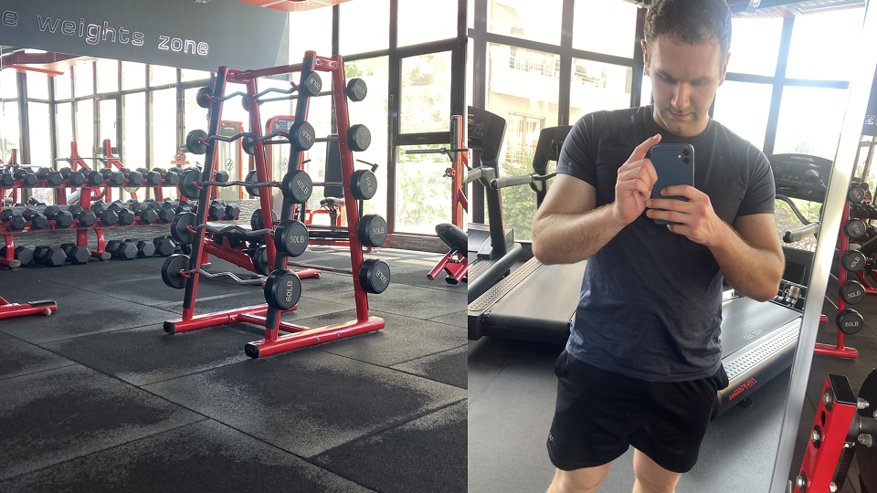 Workation Albanien: Moderner Fitnessraum mit roten Hanteln und Geräten; daneben ein Mann, der ein Selfie auf einem Laufband macht.