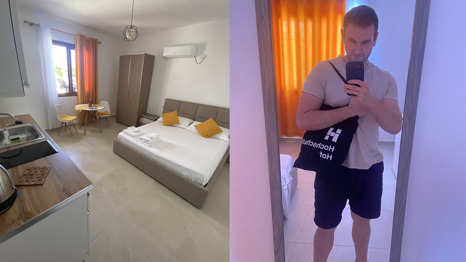 Workation Albanien: Helles Hotelzimmer mit Doppelbett und Klimaanlage; daneben ein Spiegelselfie vor orangefarbenem Vorhang.